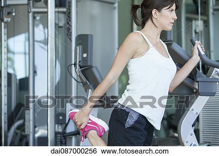 Woman stretching before working out View Large Photo Image Stock Photograph - Woman stretching before working out. Fotosearch
