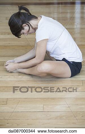 Woman stretching on the floor View Large Photo Image Picture - Woman stretching on the floor. Fotosearch