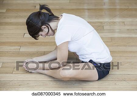 Stock Photography - Woman stretching on the floor. Fotosearch