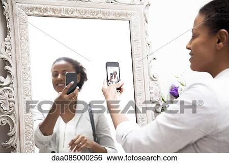 Woman taking selfie in mirror View Large Photo Image Stock Photograph - Woman taking selfie in mirror. Fotosearch