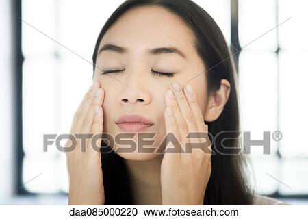 Woman touching her face, eyes closed View Large Photo Image Stock Image - Woman touching her face, eyes closed. Fotosearch