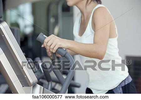 Woman using exercise machine in fitness club, cropped View Large Photo Image Stock Photo - Woman using exercise machine in fitness club, cropped. Fotosearch