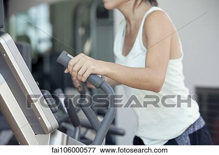 Woman using exercise machine in fitness club, cropped View Large Photo Image Stock Photo - Woman using exercise machine in fitness club, cropped. Fotosearch