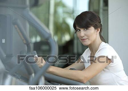 Woman using exercise machine in health club View Large Photo Image Stock Photography - Woman using exercise machine in health club. Fotosearch