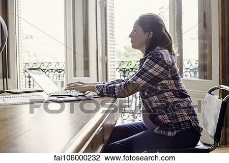 Woman using laptop computer at home View Large Photo Image Stock Image - Woman using laptop computer at home. Fotosearch