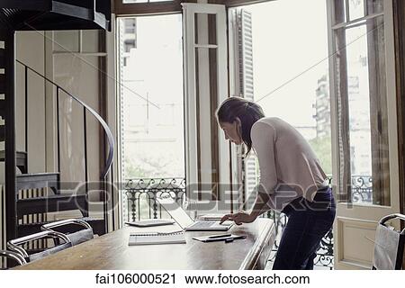 Stock Image - Woman using laptop computer at home. Fotosearch