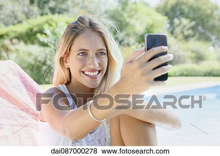 Woman using smartphone by pool View Large Photo Image Stock Photo - Woman using smartphone by pool. Fotosearch