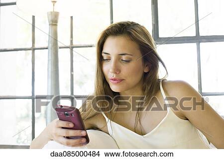 Picture - Woman using smartphone. Fotosearch