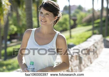 Woman walking in park with water bottle View Large Photo Image Stock Photo - Woman walking in park with water bottle. Fotosearch