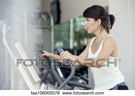 Woman working out in fitness club View Large Photo Image Stock Photo - Woman working out in fitness club. Fotosearch