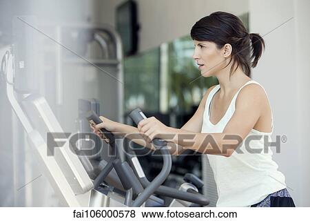 Stock Photo - Woman working out in fitness club. Fotosearch