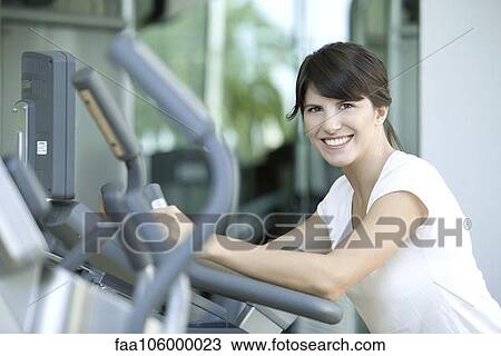 Woman working out in health club, smiling cheerfully View Large Photo Image Stock Image - Woman working out in health club, smiling cheerfully. Fotosearch