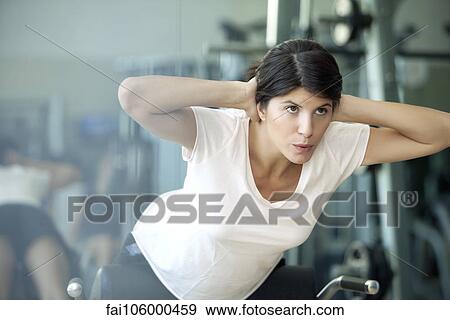 Stock Photo - Woman working out in health club. Fotosearch