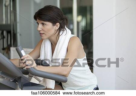 Picture - Woman working out on fitness machine. Fotosearch