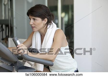 Woman working out on fitness machine View Large Photo Image Picture - Woman working out on fitness machine. Fotosearch