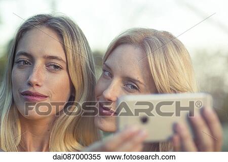 Women posing together for smartphone selfie View Large Photo Image Stock Photography - Women posing together for smartphone selfie. Fotosearch