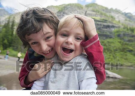Stock Photo - Young brothers laughing together, portrait. Fotosearch