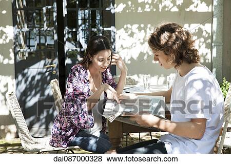 Young couple discussing news in newspaper View Large Photo Image Stock Photo - Young couple discussing news in newspaper. Fotosearch