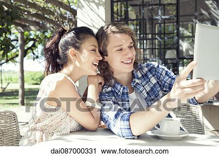 Young couple taking selfie with digital tablet View Large Photo Image Stock Image - Young couple taking selfie with digital tablet. Fotosearch