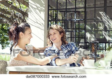 Young couple using digital tablet outdoors View Large Photo Image Stock Image - Young couple using digital tablet outdoors. Fotosearch