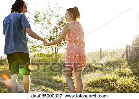 Young couple walking together along countryside footpath View Large Photo Image Stock Photo - Young couple walking together along countryside footpath. Fotosearch