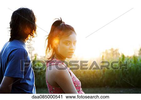 Stock Image - Young couple watching sunset. Fotosearch