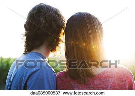 Young couple watching sunset View Large Photo Image Stock Photo - Young couple watching sunset. Fotosearch