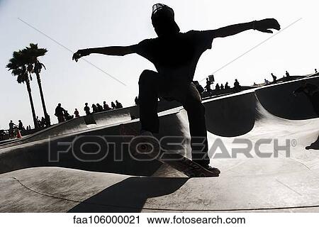 Young man skateboarding in skate park View Large Photo Image Stock Image - Young man skateboarding in skate park. Fotosearch