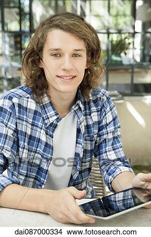 Young man using digital tablet outdoors View Large Photo Image Picture - Young man using digital tablet outdoors. Fotosearch