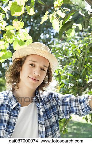 Picture - Young man wearing sun hat, portrait. Fotosearch