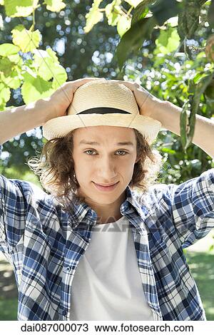 Young man wearing sun hat, portrait View Large Photo Image Stock Image - Young man wearing sun hat, portrait. Fotosearch