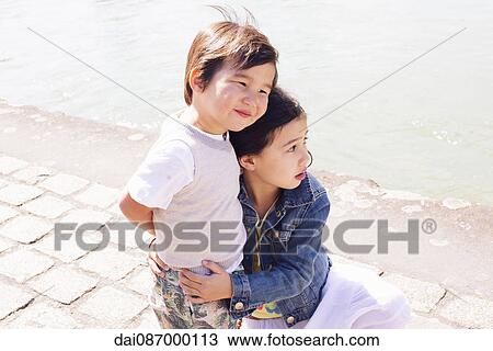 Young siblings embracing outdoors View Large Photo Image Stock Image - Young siblings embracing outdoors. Fotosearch