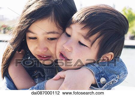 Stock Image - Young siblings embracing. Fotosearch