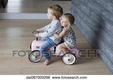 Young siblings riding on toy car together View Large Photo Image Stock Photo - Young siblings riding on toy car together. Fotosearch