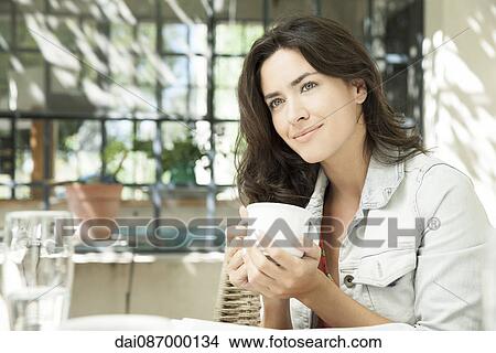 Young woman enjoying cup of coffee outdoors View Large Photo Image Picture - Young woman enjoying cup of coffee outdoors. Fotosearch