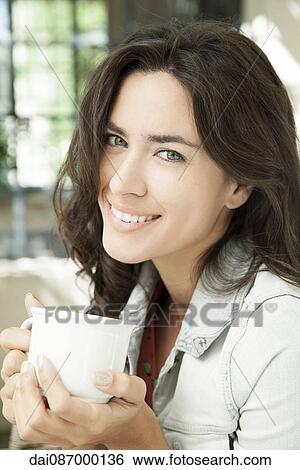 Young woman enjoying cup of coffee outdoors View Large Photo Image Stock Photograph - Young woman enjoying cup of coffee outdoors. Fotosearch