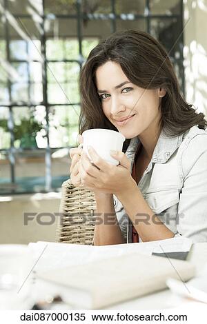 Young woman enjoying cup of coffee outdoors View Large Photo Image Stock Photography - Young woman enjoying cup of coffee outdoors. Fotosearch