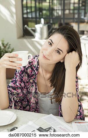 Stock Photography - Young woman enjoying cup of coffee outdoors. Fotosearch