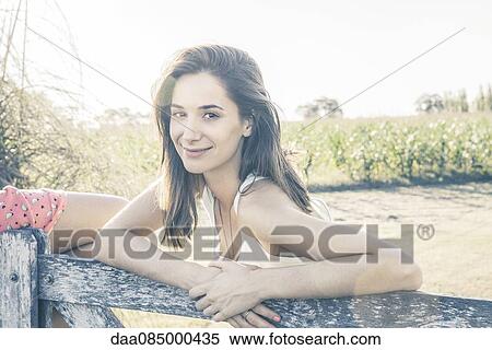 Stock Photography - Young woman spending day in countryside, portrait. Fotosearch