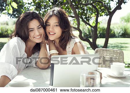Stock Image - Young women taking selfie using digital tablet. Fotosearch