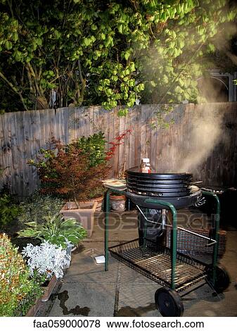 Stock Photo - Barbecue grill being used at night. Fotosearch
