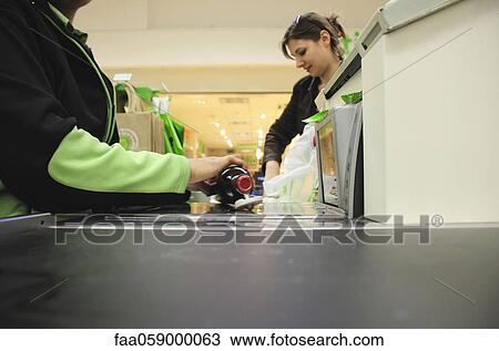 Cashier scanning groceries at checkout counter View Large Photo Image Stock Image - Cashier scanning groceries at checkout counter. Fotosearch