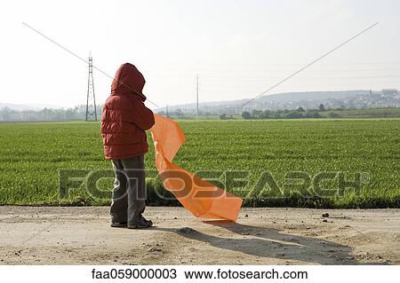 Stock Image - Child with plastic bag, rear view. Fotosearch
