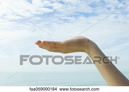 Picture - Ecology concept, cupped hand supporting the sky. Fotosearch