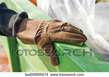 Gloved hand holding onto edge of dumpster View Large Photo Image Picture - Gloved hand holding onto edge of dumpster. Fotosearch