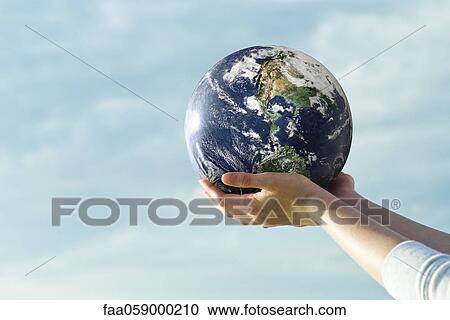 Stock Image - Holding fitness ball in cupped hands. Fotosearch