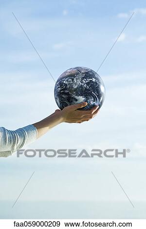 Stock Photo - Holding fitness ball in cupped hands. Fotosearch