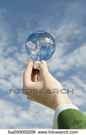 Person holding light bulb in front of sky View Large Photo Image Stock Photo - Person holding light bulb in front of sky. Fotosearch