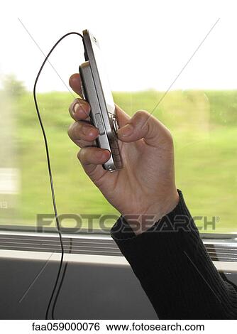 Stock Photograph - Person using cell phone on train, cropped. Fotosearch