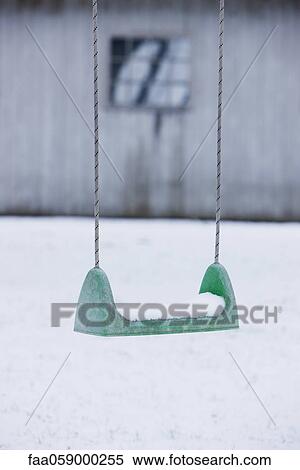 Stock Photography - Playground swing covered in snow. Fotosearch